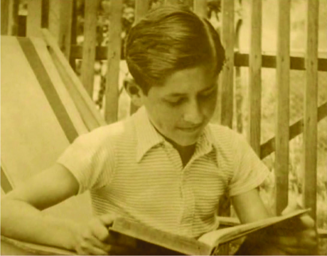 9. Julije u dječačkoj dobi s knjigom, u ljetnoj dokolici na dvorištu.